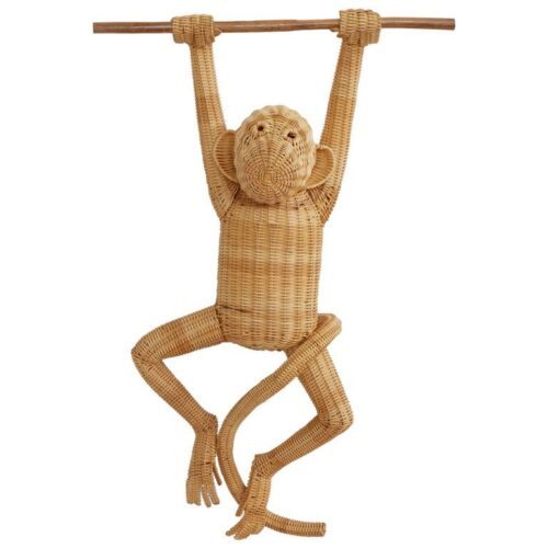 Mono de mimbre hecho a mano atado a una rama de madera