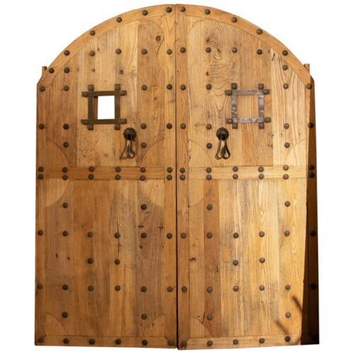 Puerta de madera doble andaluza antigua de los años 50 con arco y clavos de hierro