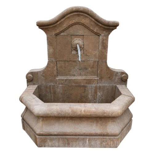 Fuente de pared de piedra natural con cerco y caño decorativo.